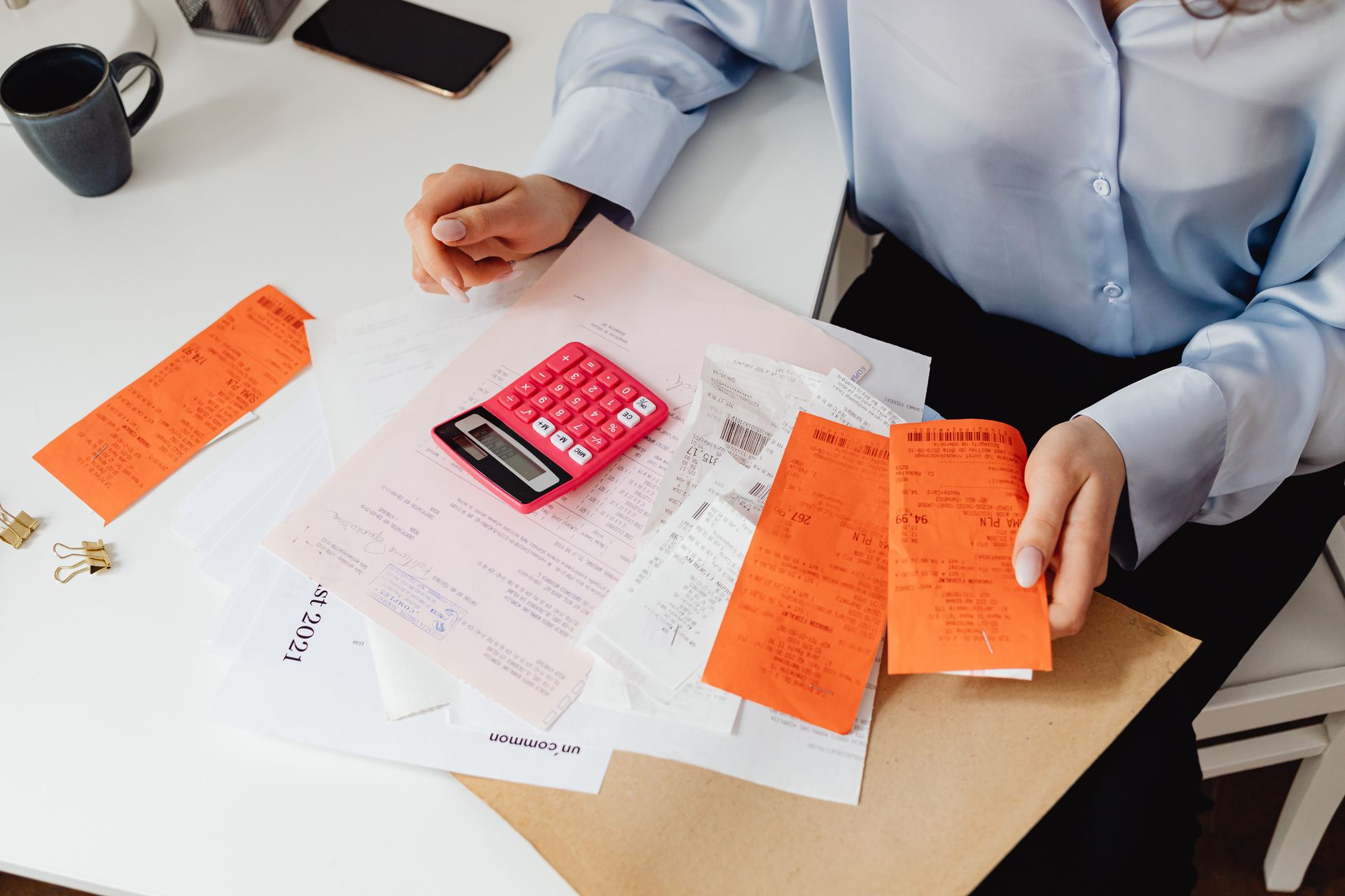 Small business owner reviewing receipts with a calculator for bookkeeping services